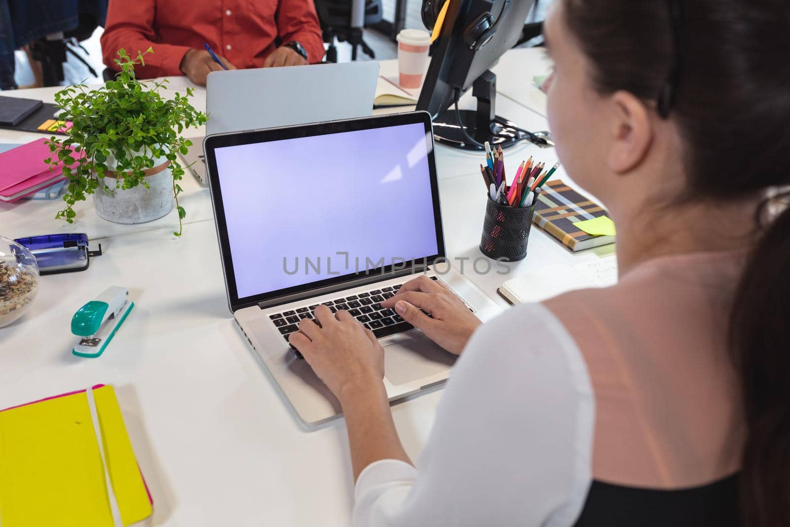 Caucasian female creative worker sitting at desk using laptop by Wavebreakmedia