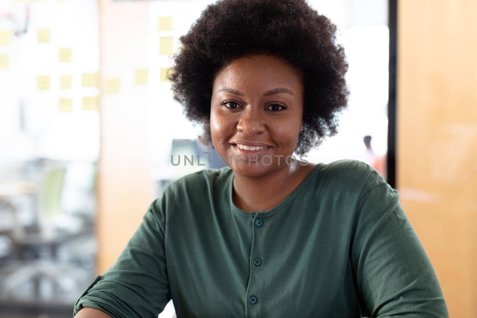 Portrait of african american businesswoman looking to camera and smiling. business person in a modern office.