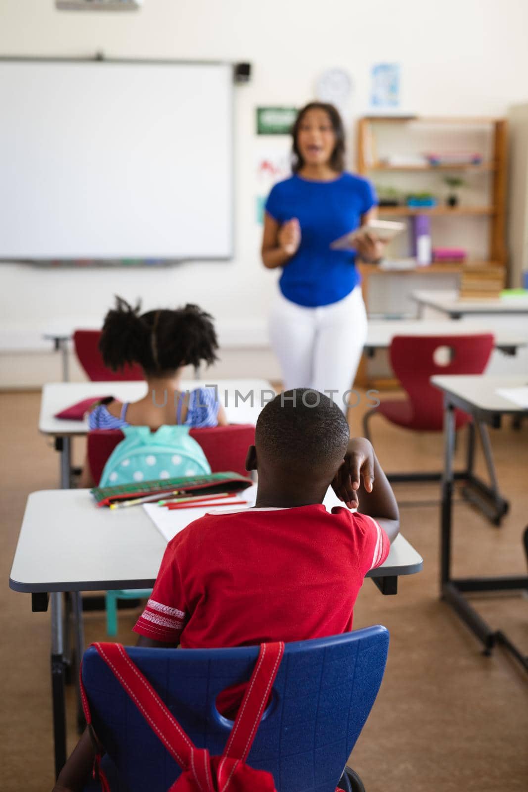 African american female teacher teaching students in the class at elementary school by Wavebreakmedia