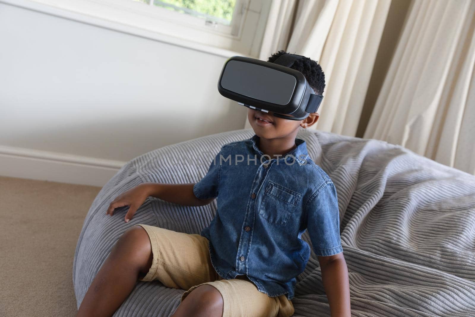 Happy african american boy using vr headset and smiling at home by Wavebreakmedia