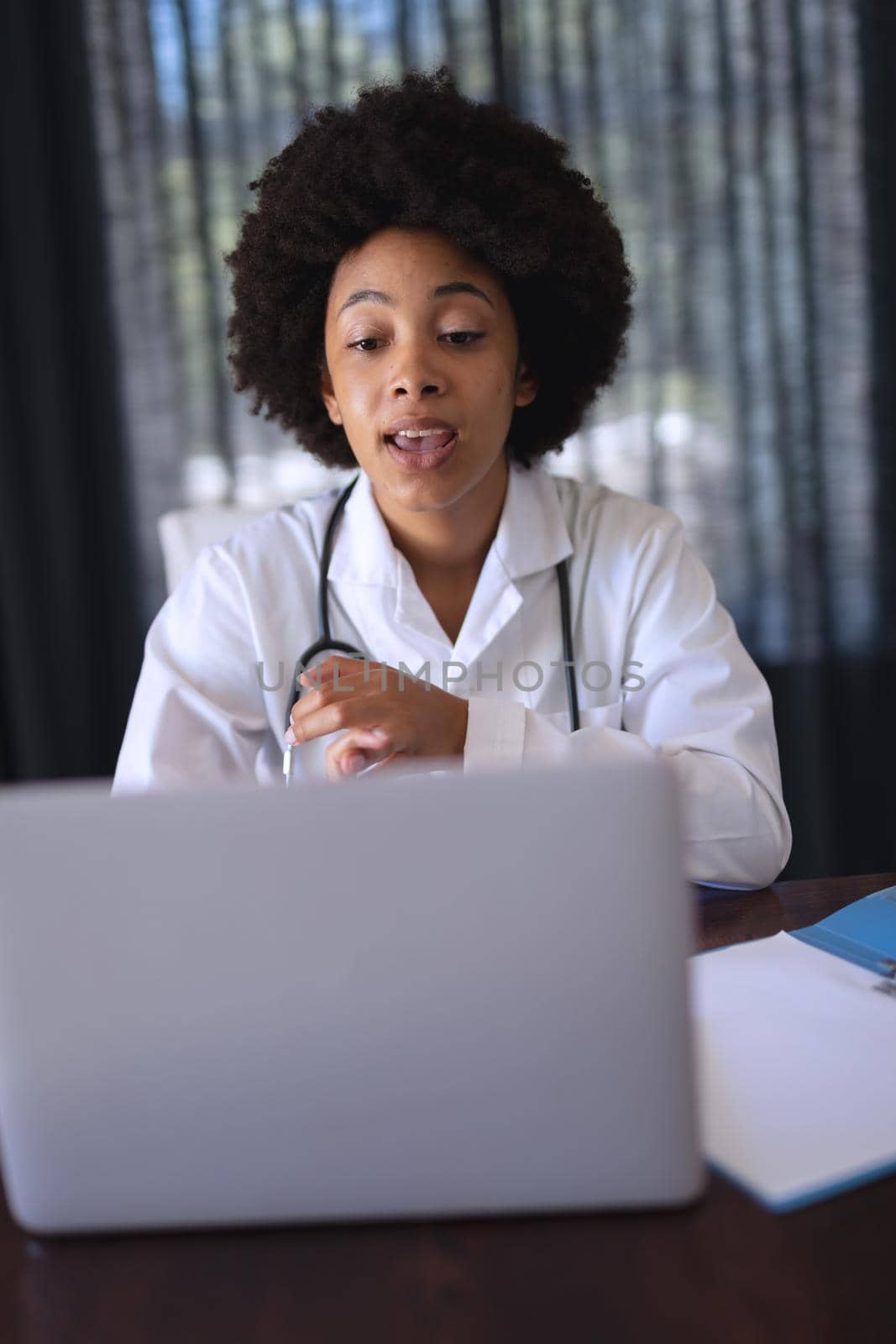 African american female doctor sitting making video call consultation by Wavebreakmedia