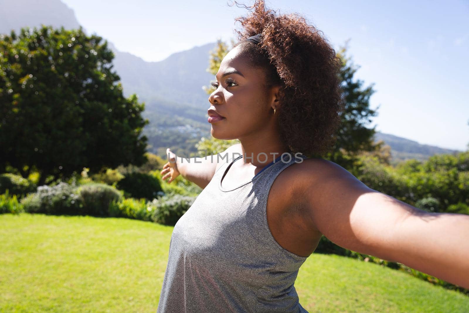 African american woman practicing yoga in sunny garden by Wavebreakmedia