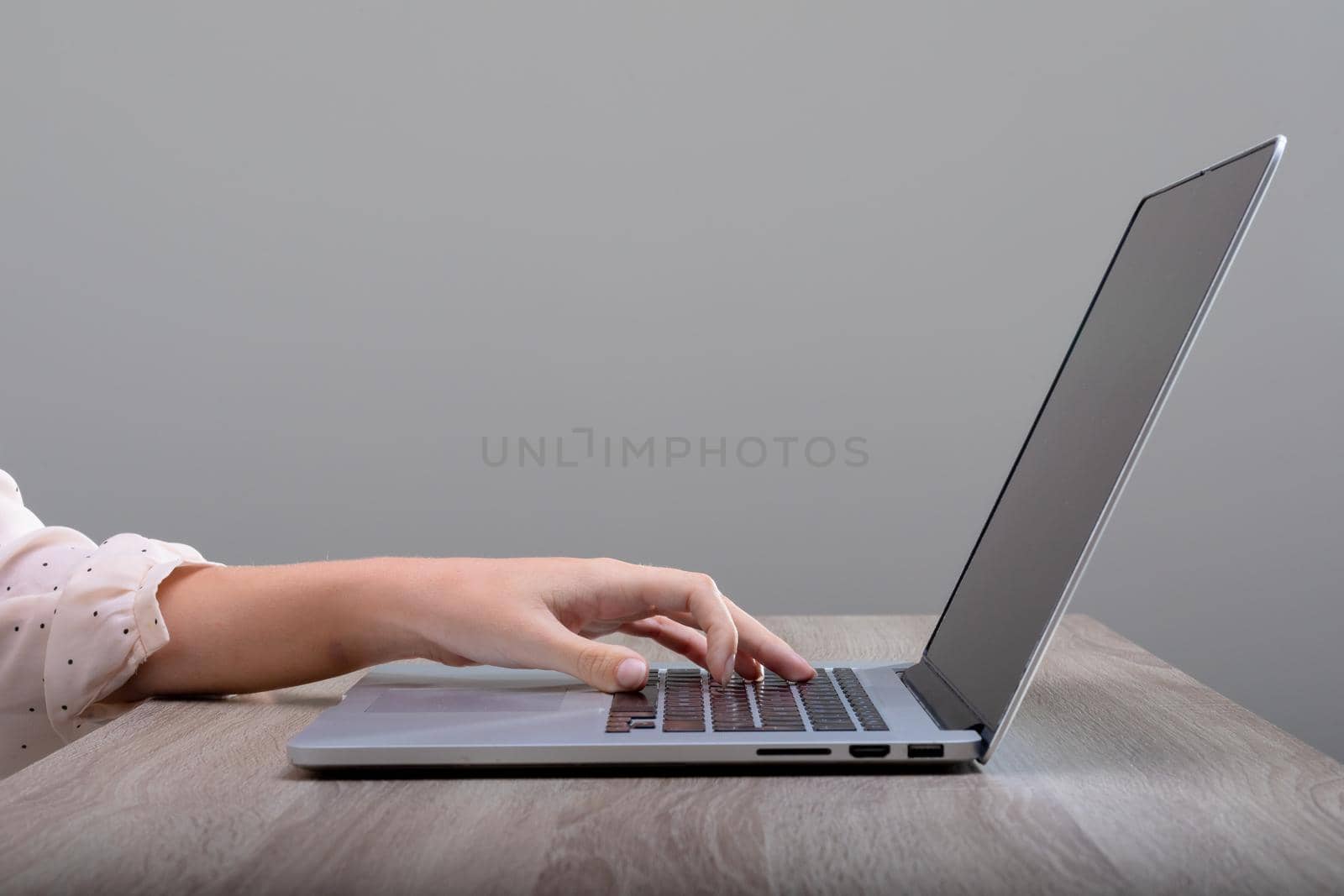 Midsection of caucasian businesswoman using laptop, isolated on grey background by Wavebreakmedia