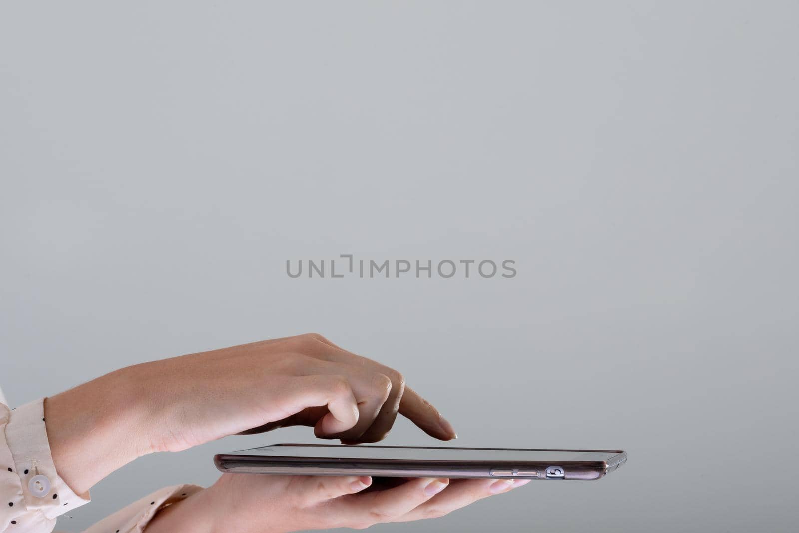 Close up of caucasian businesswoman using tablet, isolated on grey background. business, technology, communication and growth concept.