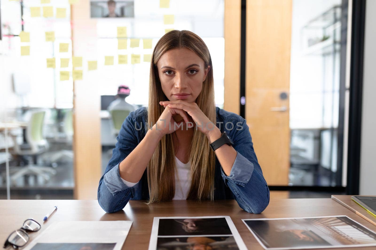 Caucasian businesswoman sitting at desk having video call conversation looking to camera by Wavebreakmedia