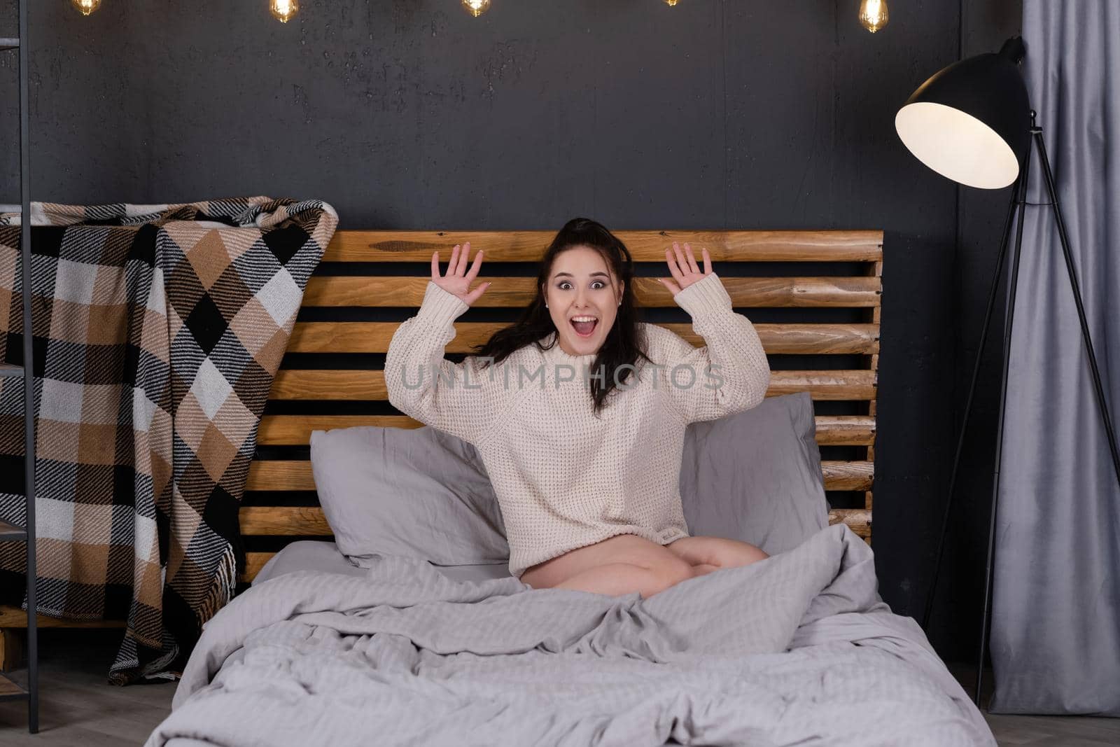 pretty woman indoor portrait. Young beautiful woman in warm knitted sweater at home on bed in morning. fashion. happy, sexy legs, lazy, sleepy.