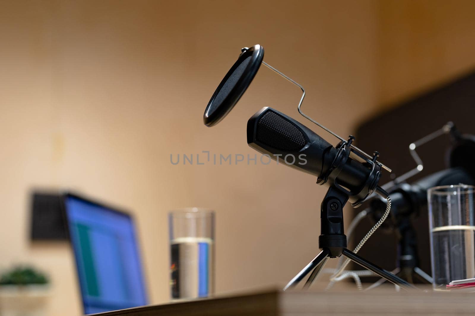 Office desk with microphones, laptop computer and glasses of water. business items in a modern office.