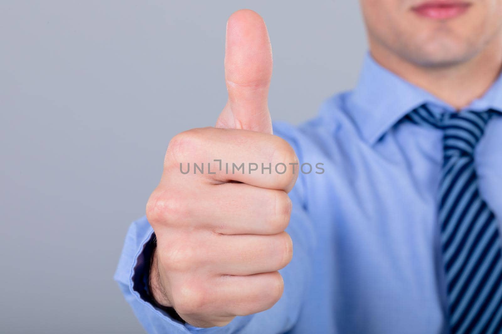 Midsection of caucasian businessman with thumb up, isolated on grey background. business technology, communication and growth concept.