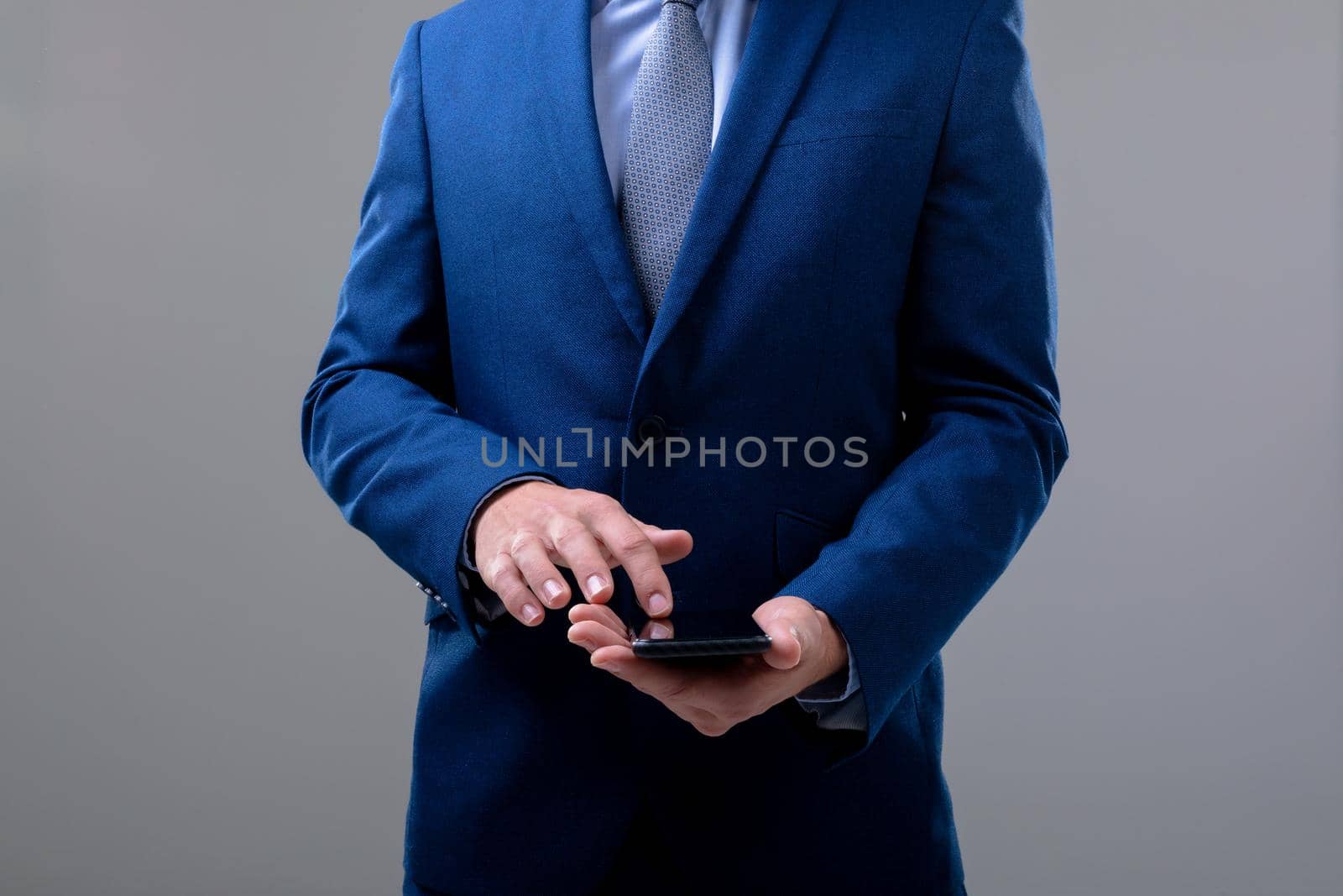 Midsection of caucasian businessman using smartphone, isolated on grey background. business technology, communication and growth concept.
