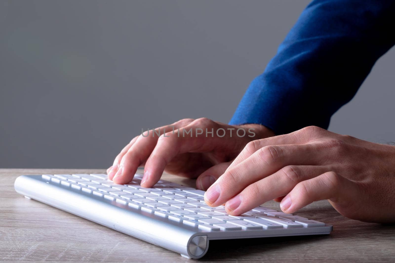 Close up of caucasian businessman typing on keyboard, isolated on grey background. business technology, communication and growth concept digitally generated composite image.