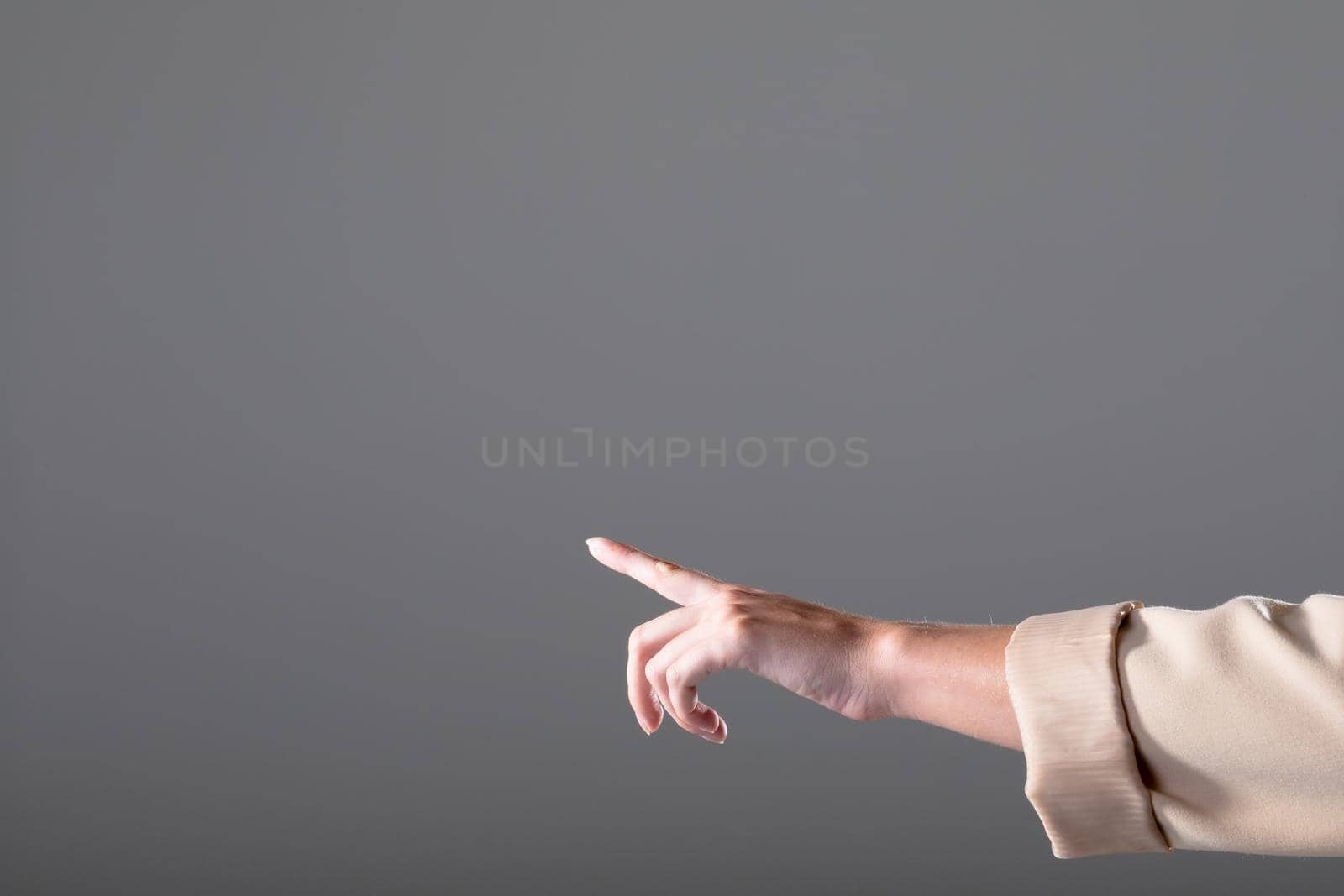 Midsection of caucasian businesswoman pointing with her finger, isolated on grey background. business, technology, communication and growth concept. age.