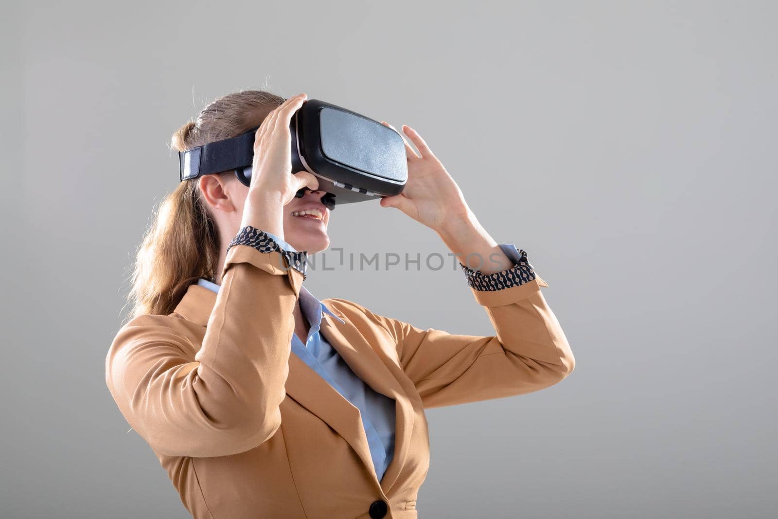 Caucasian businesswoman wearing vr headset, isolated on grey background. business, technology, communication and growth concept.