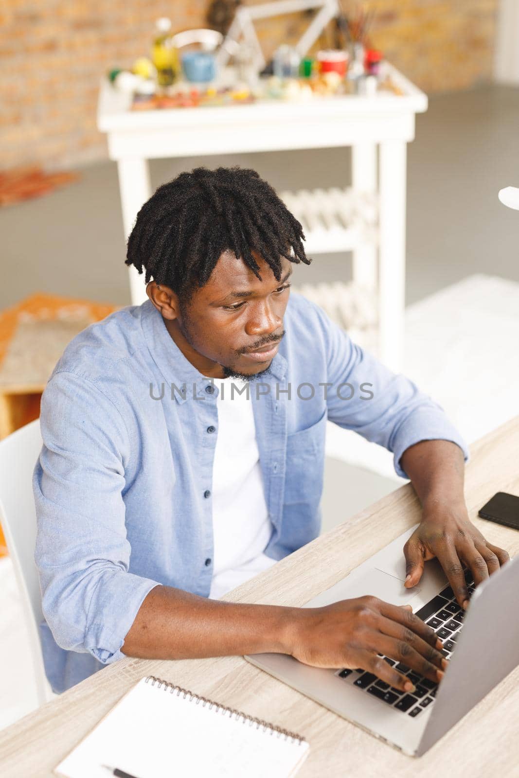 African american male painter at work using laptop in art studio by Wavebreakmedia