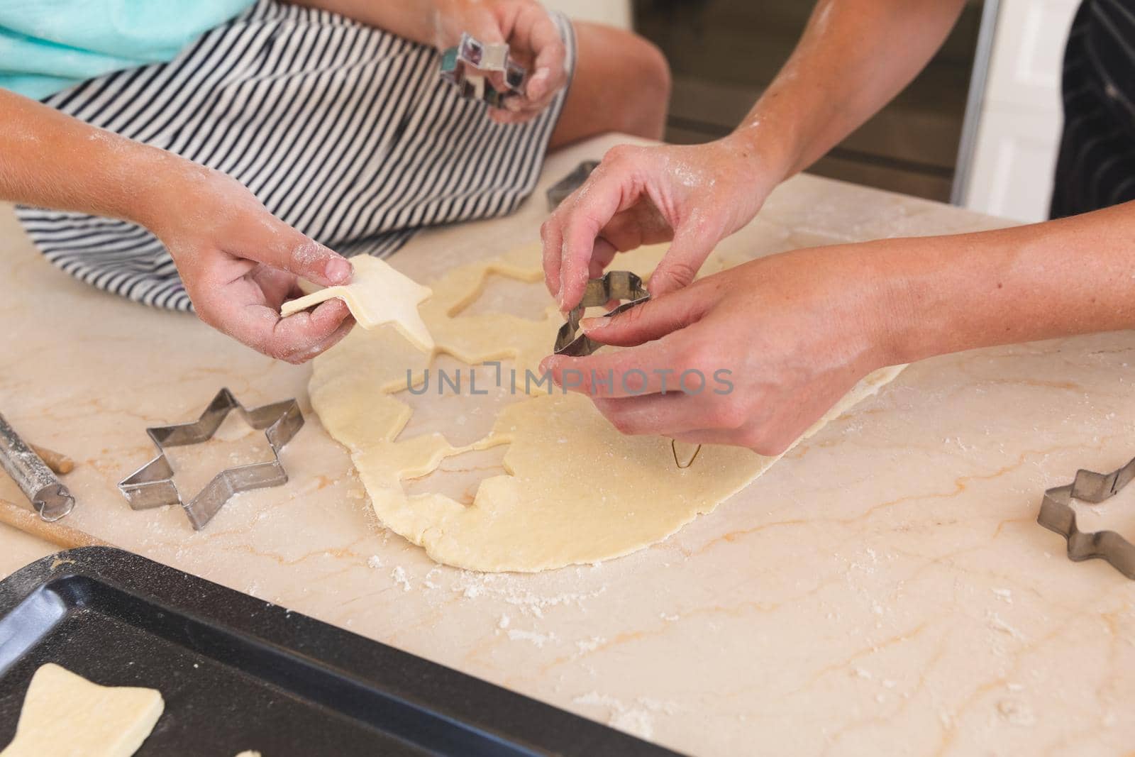 Caucasian mother and daughter baking together in kitchen, cutting cookies by Wavebreakmedia