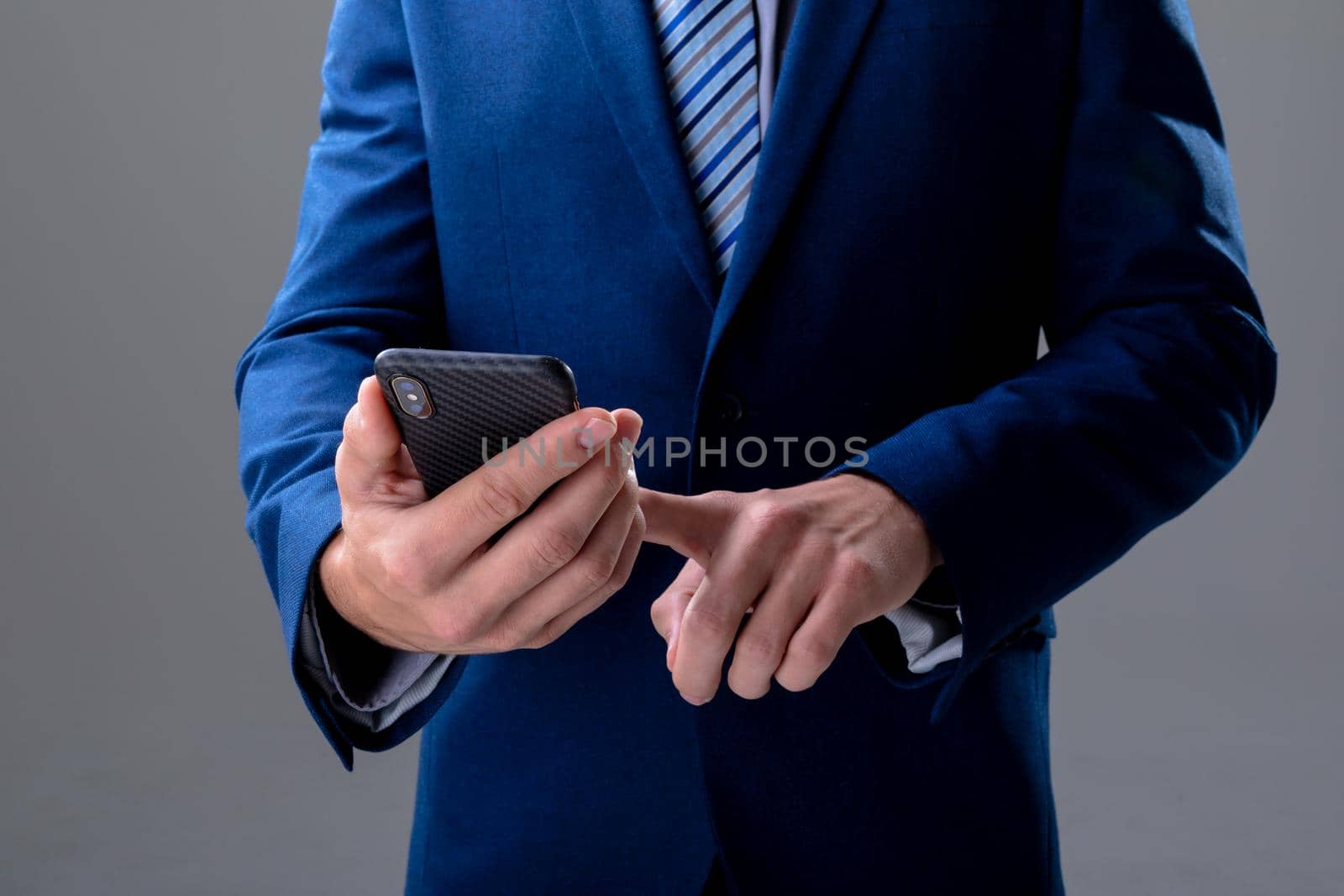 Midsection of caucasian businessman using smartphone, isolated on grey background. business technology, communication and growth concept.