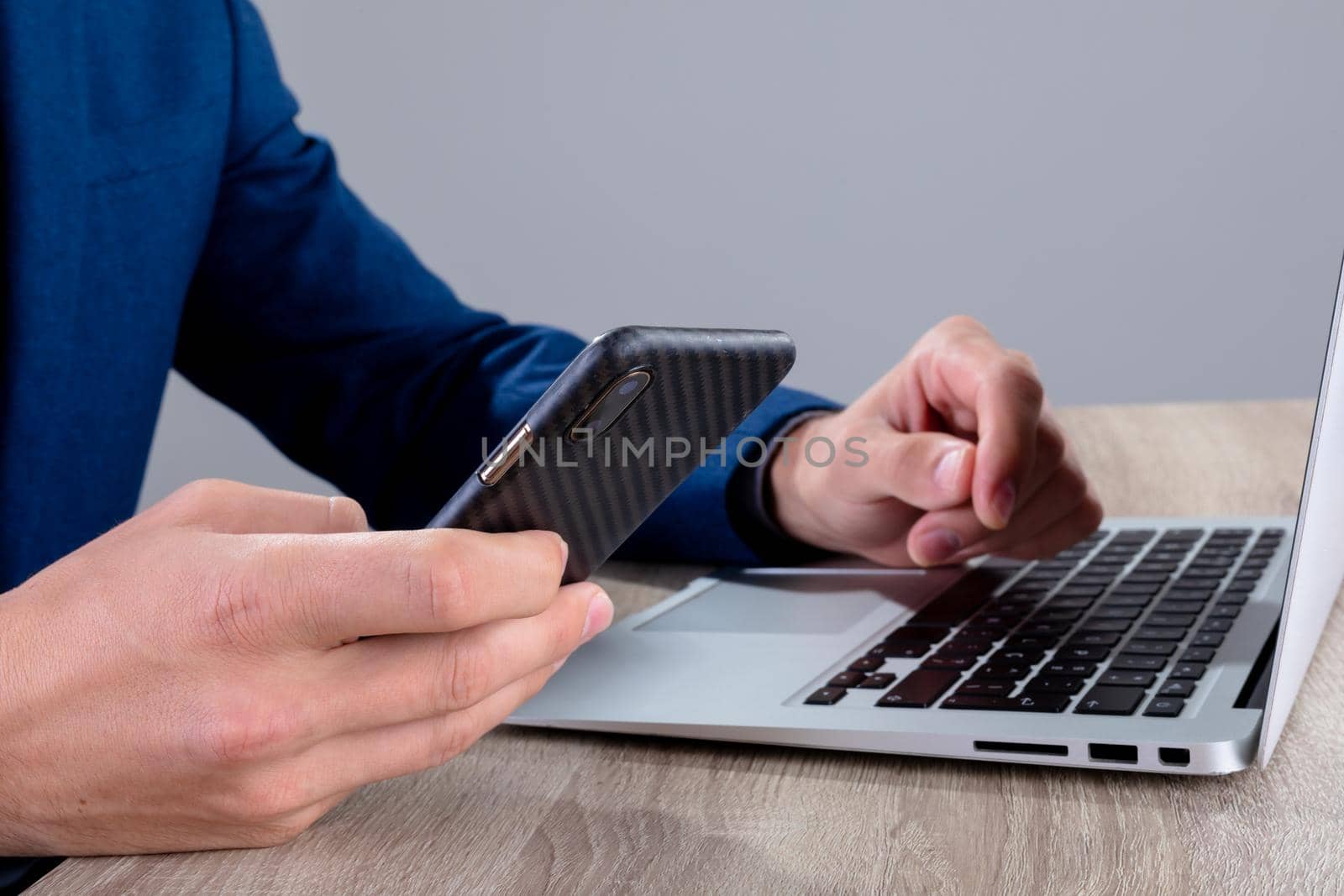 Midsection of caucasian businessman using smartphone and laptop, isolated on grey background by Wavebreakmedia