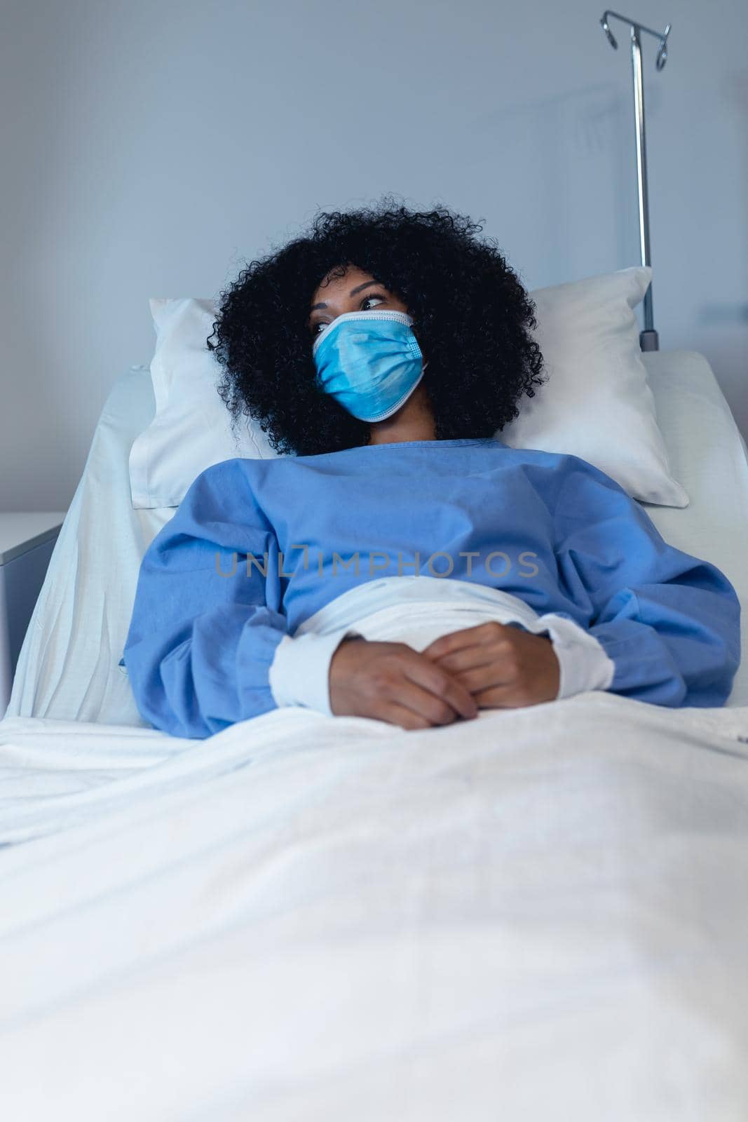 African american female patient lying in hospital bed wearing face mask by Wavebreakmedia
