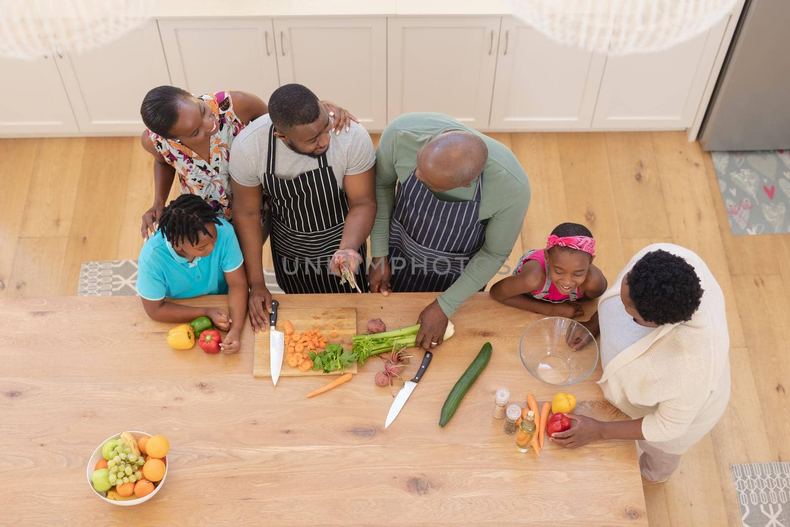 African american parents cooking with son and daughter and grandparents in the kitchen. three generation family spending quality time together. . three generation family spending quality time