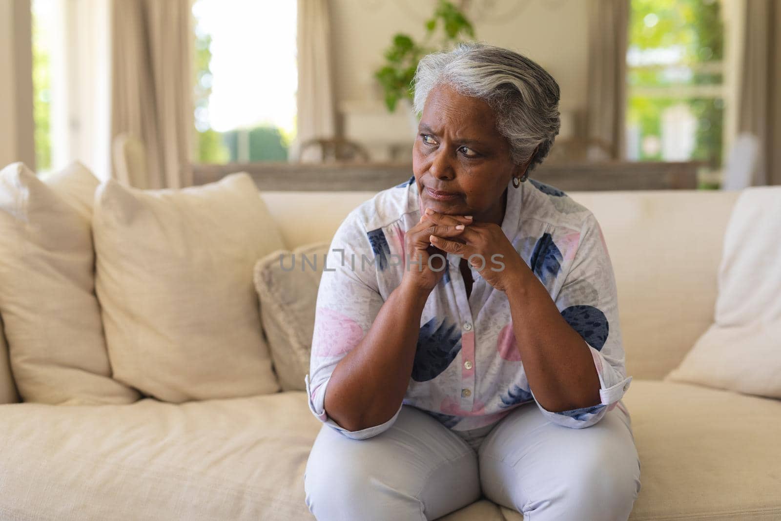 Senior african american woman sitting on sofa and thinking. retreat, retirement and senior lifestyle concept.