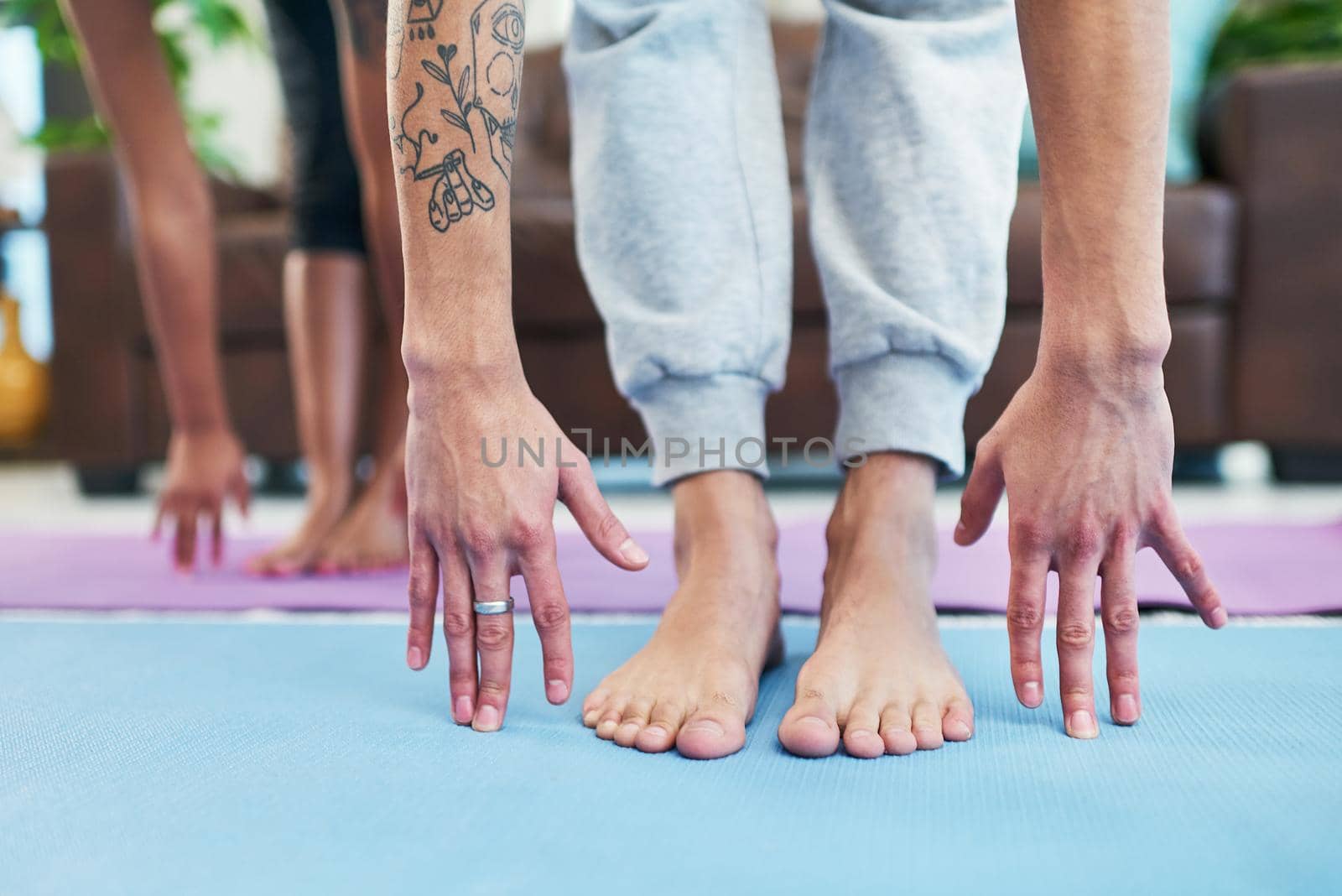 Yoga helped us to find balance in our relationship. Cropped shot of an unrecognizable couple practising yoga at home. by YuriArcurs