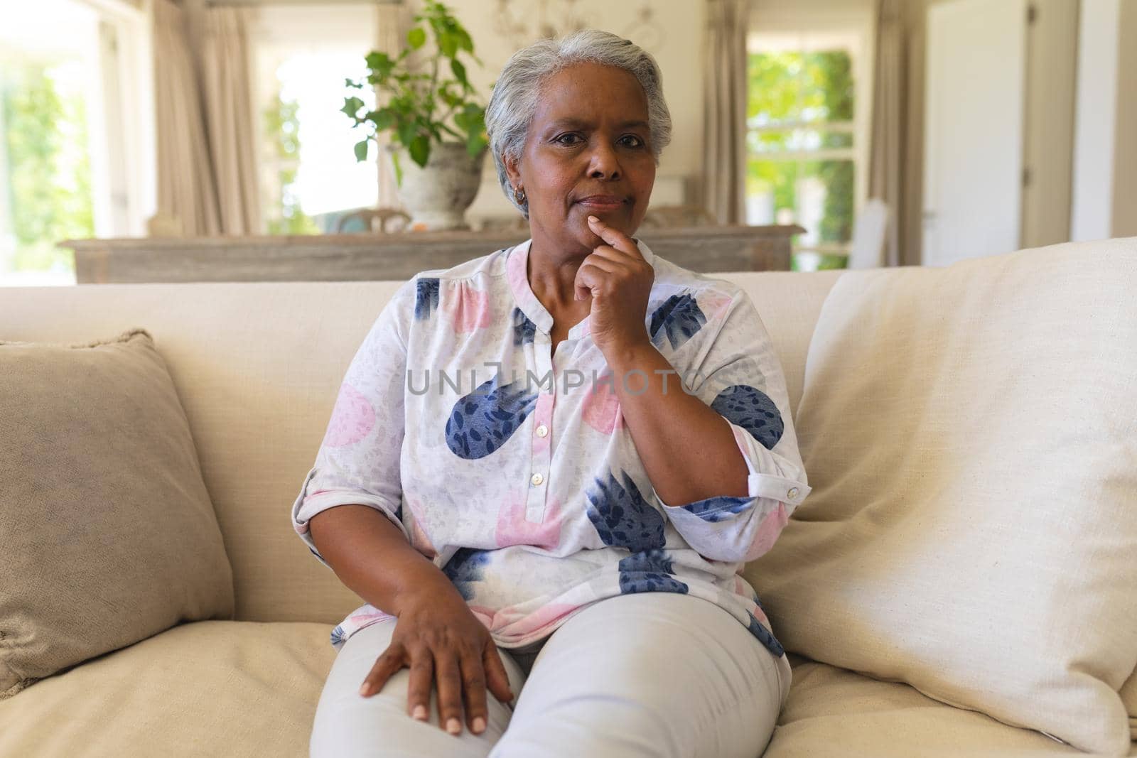 Portrait of senior african american woman sitting on sofa looking at camera. retreat, retirement and happy senior lifestyle concept.