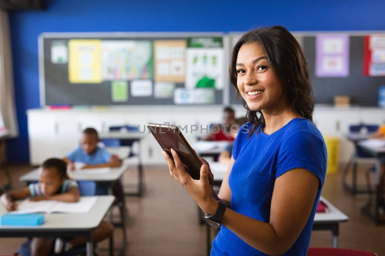 Portrait of african american female teacher holding digital tablet in the class at school. school and education concept