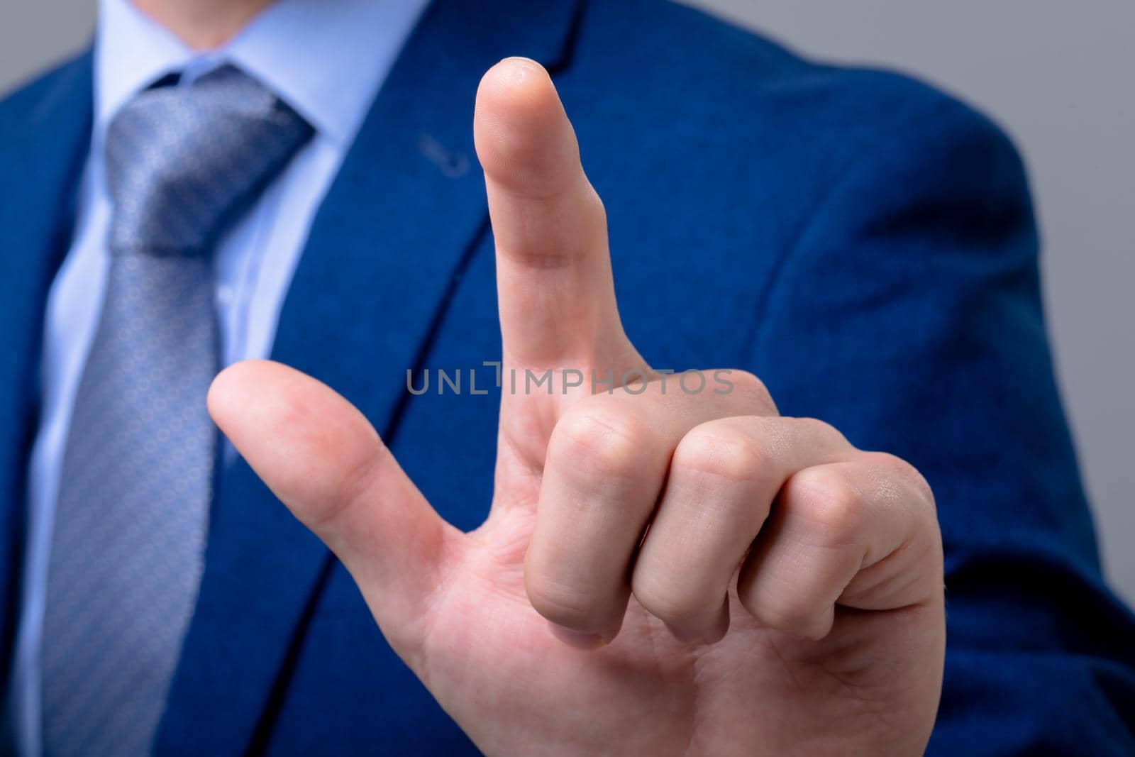 Midsection of caucasian businessman touching virtual interface, isolated on grey background by Wavebreakmedia