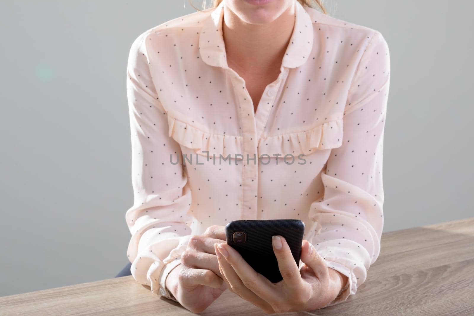 Midsection of caucasian businesswoman using smartphone, isolated on grey background. business, technology, communication and growth concept.