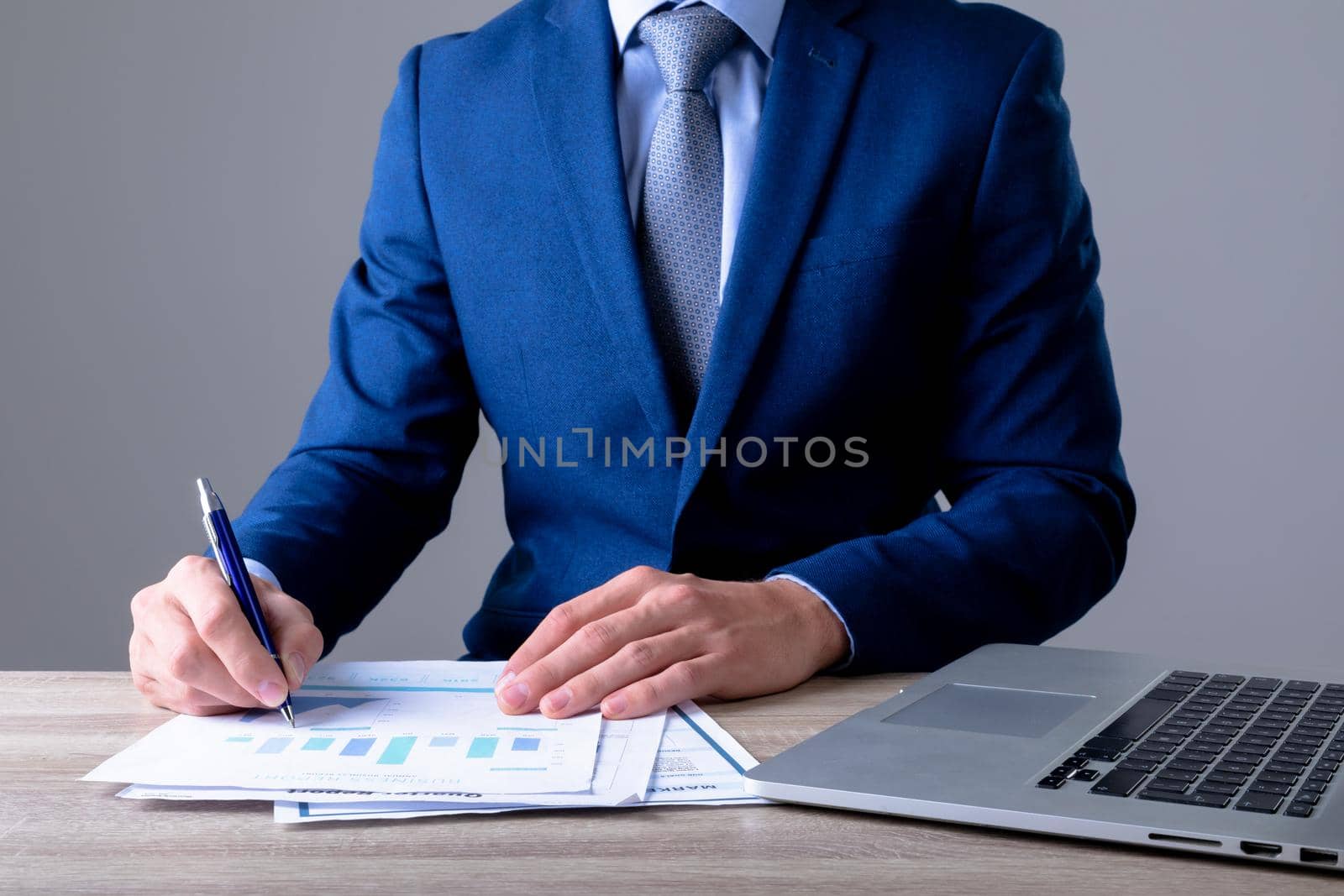 Midsection of caucasian businessman using laptop and taking notes, isolated on grey background. business technology, communication and growth concept.