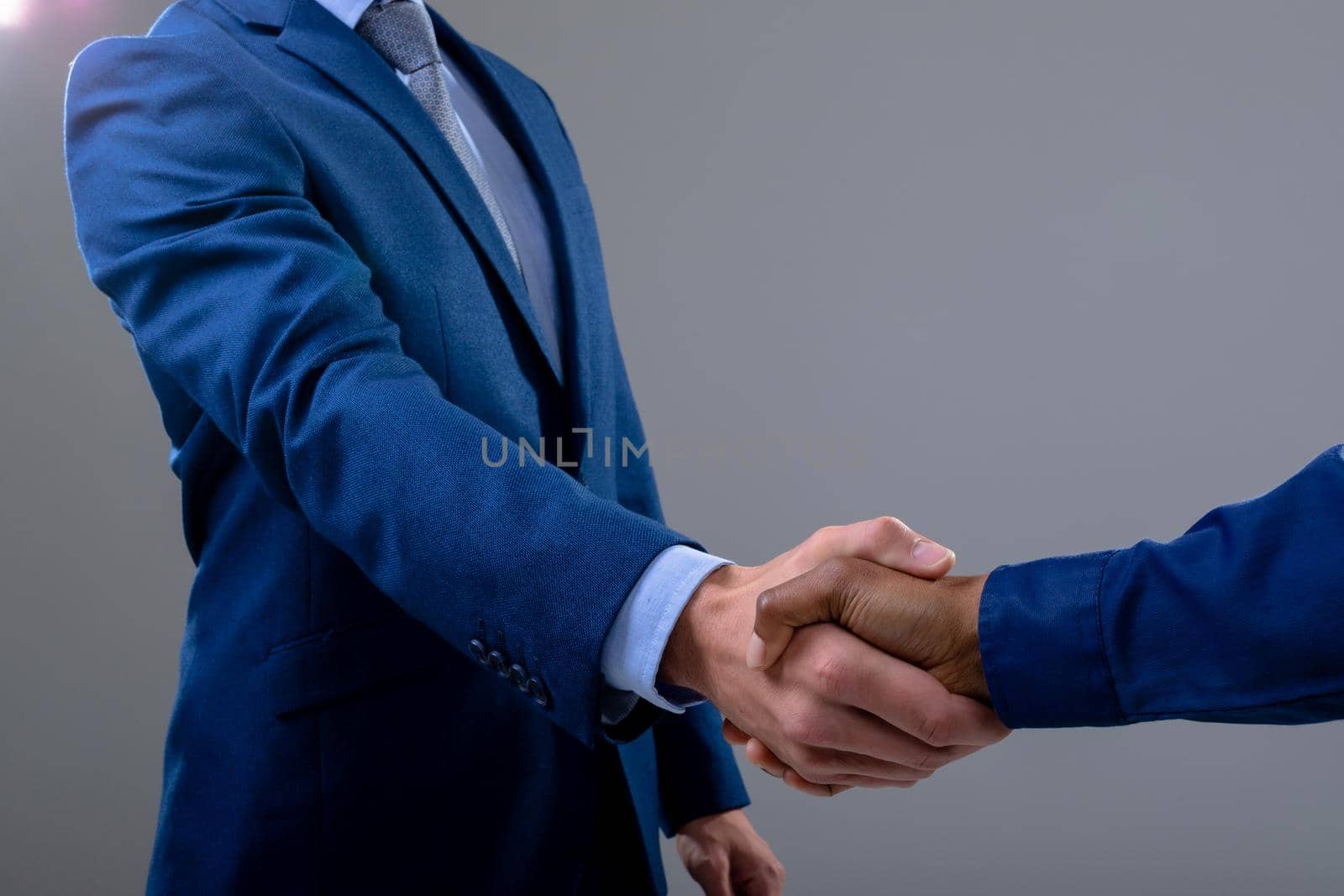 Caucasian and african american business people shaking hands, isolated on grey background. business technology, communication and growth concept.