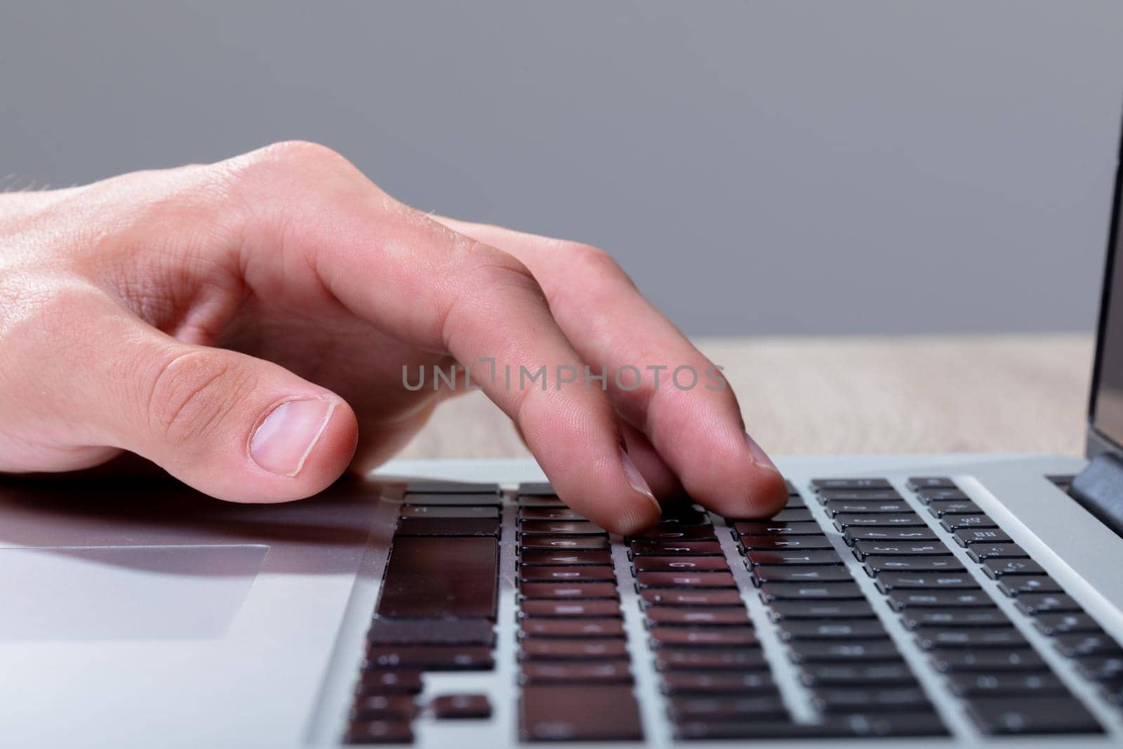 Close up of caucasian businessman typing on keyboard, isolated on grey background by Wavebreakmedia