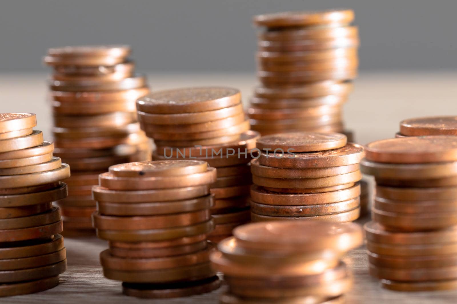 Close up of piles of coins on table, isolated on grey background by Wavebreakmedia