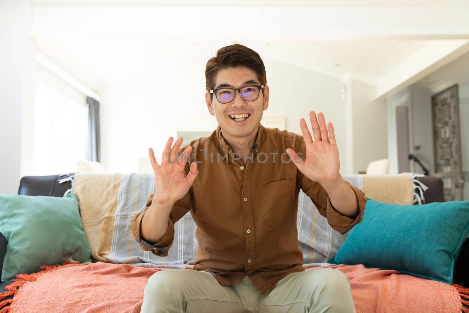 Asian man smiling during video call at home by Wavebreakmedia
