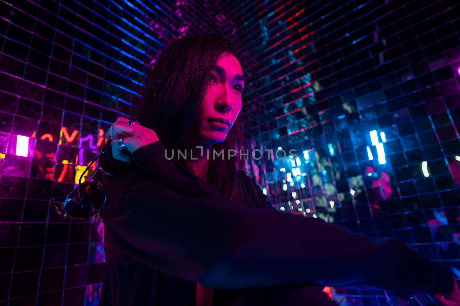 Asian man holding sunglasses. Neon photo studio. by mrwed54