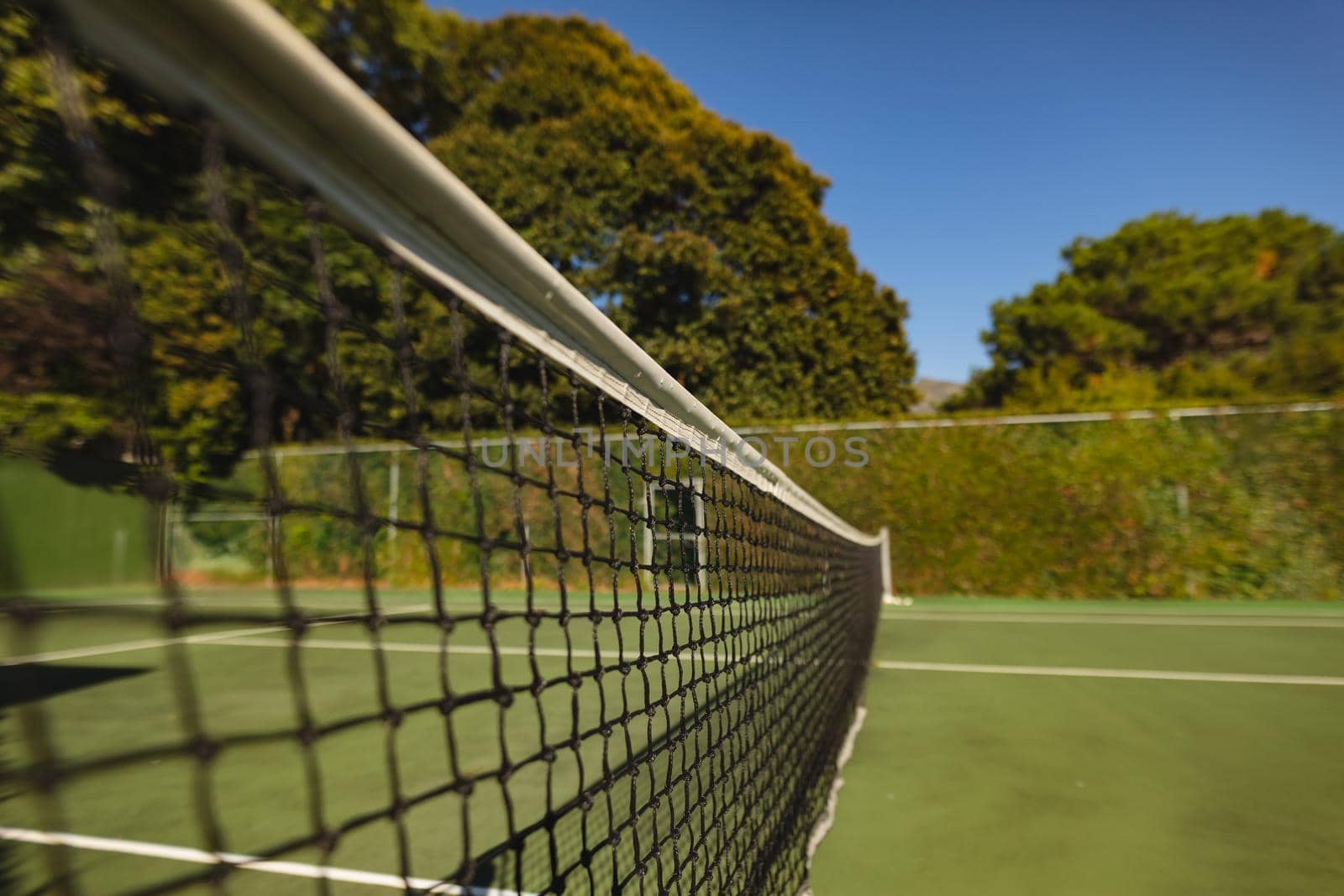 General view of tennis court and tennis net on sunny day by Wavebreakmedia