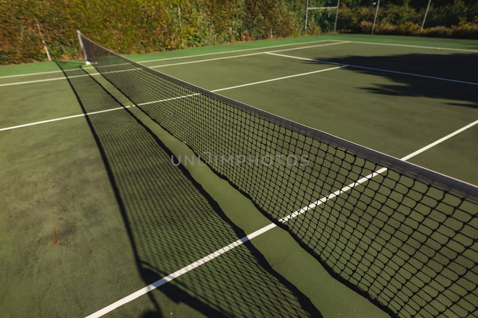 General view of tennis court and tennis net on sunny day by Wavebreakmedia