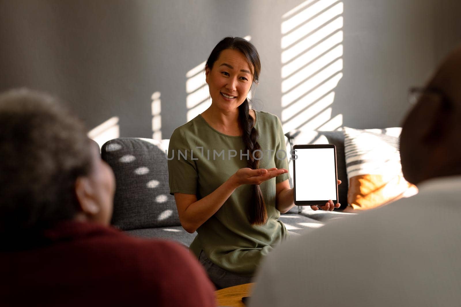 African american senior couple meeting with asian financial advisor holding tablet with copy space. retirement lifestyle, elderly support and spending time at home.