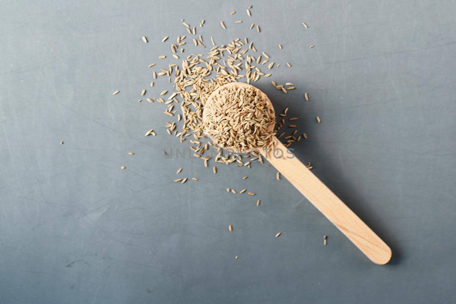 cumin seeds on spoon on table .