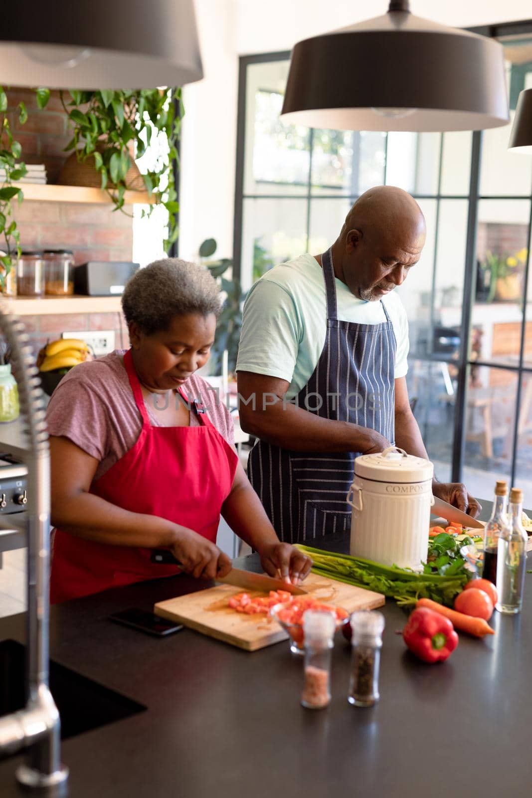Happy african american senior couple cooking together in kitchen by Wavebreakmedia
