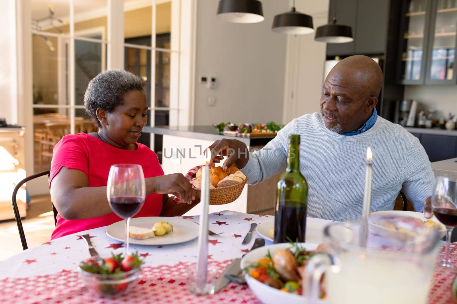 Happy african american senior couple having christmas meal at home. retirement lifestyle and christmas festivities, celebrating at home.