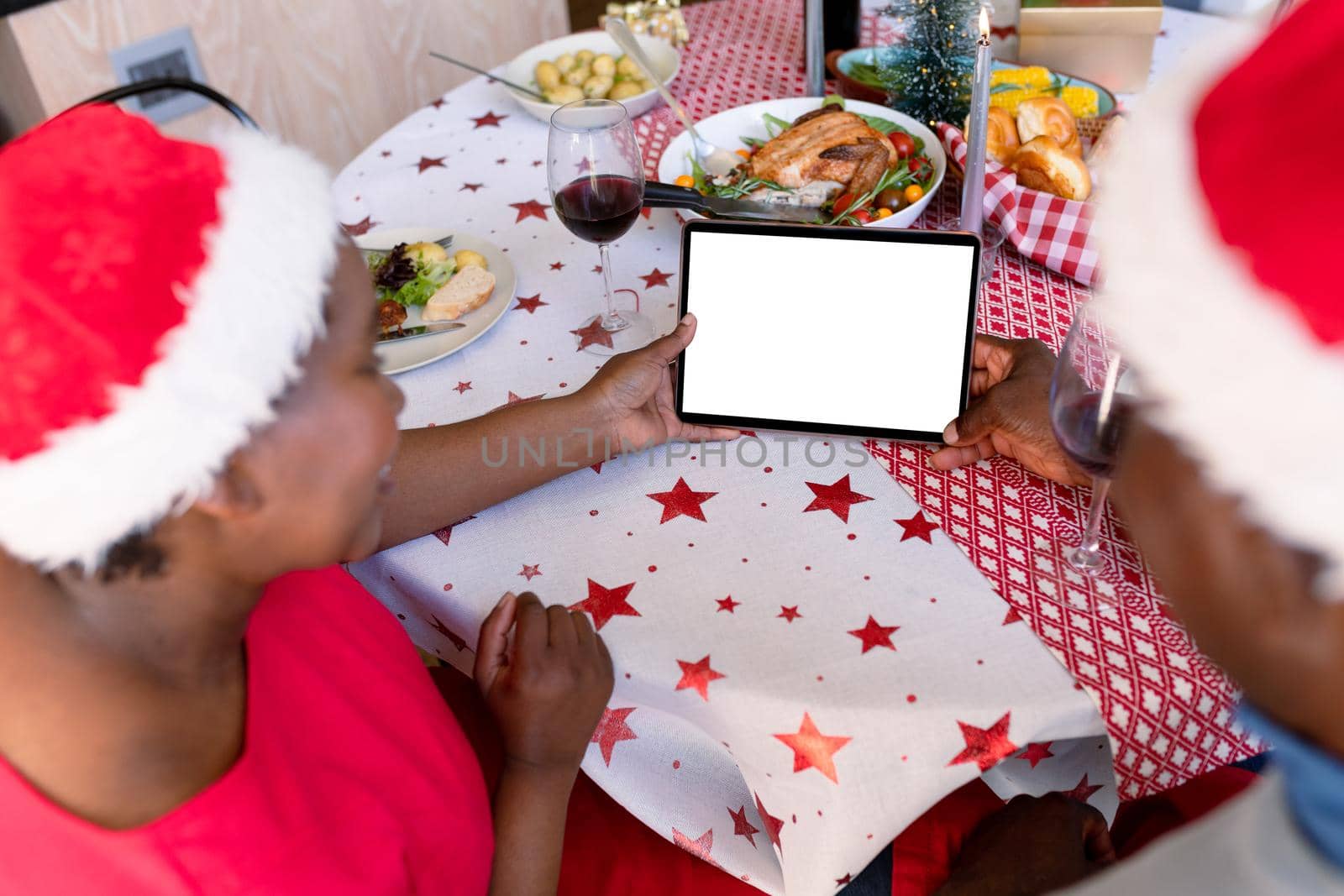 Back view of african american senior couple using tablet with copy space at christmas time by Wavebreakmedia