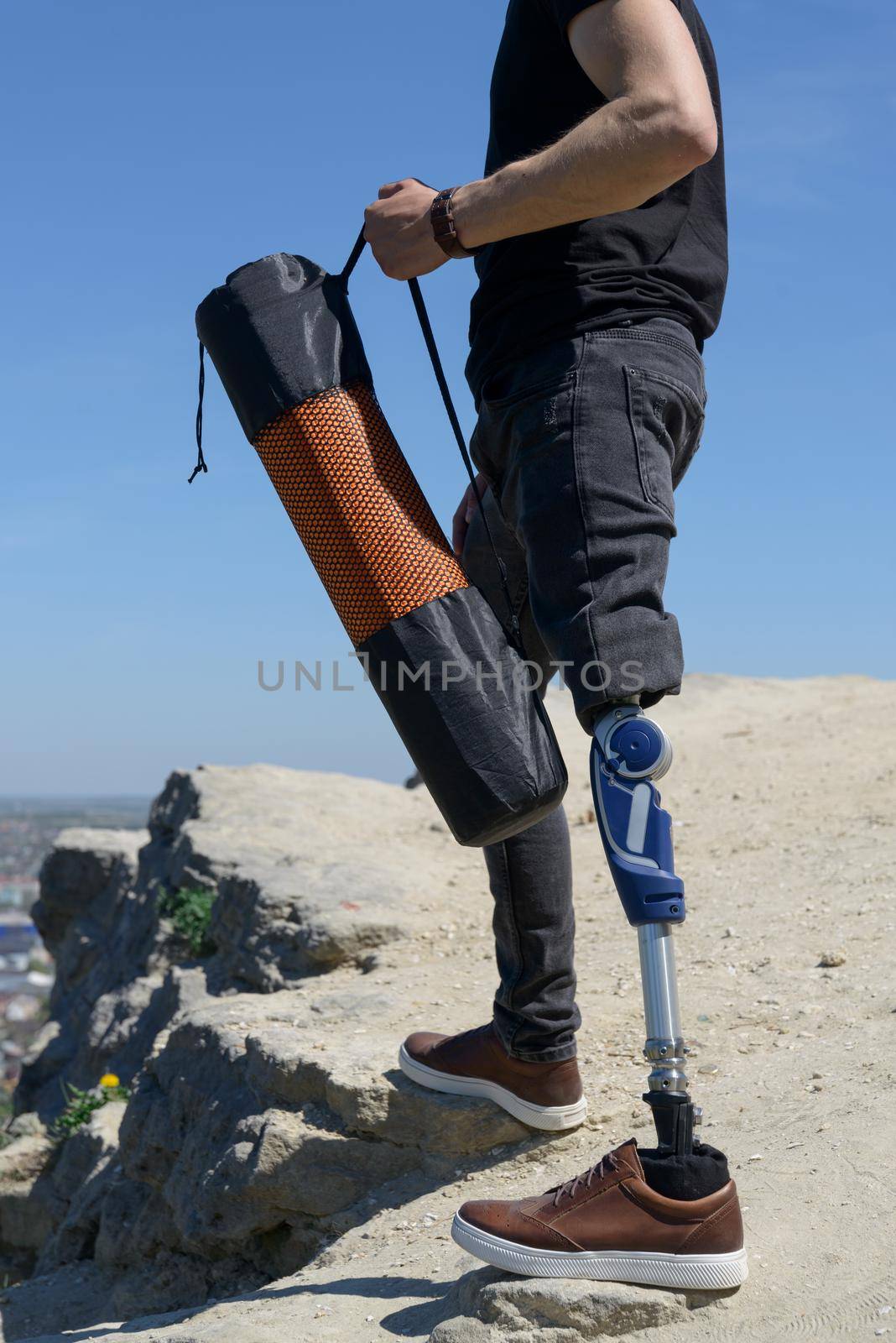 a man on a prosthetic leg travels the mountains. Dressed in black jeans and a T-shirt, he carrying mat by Ashtray25