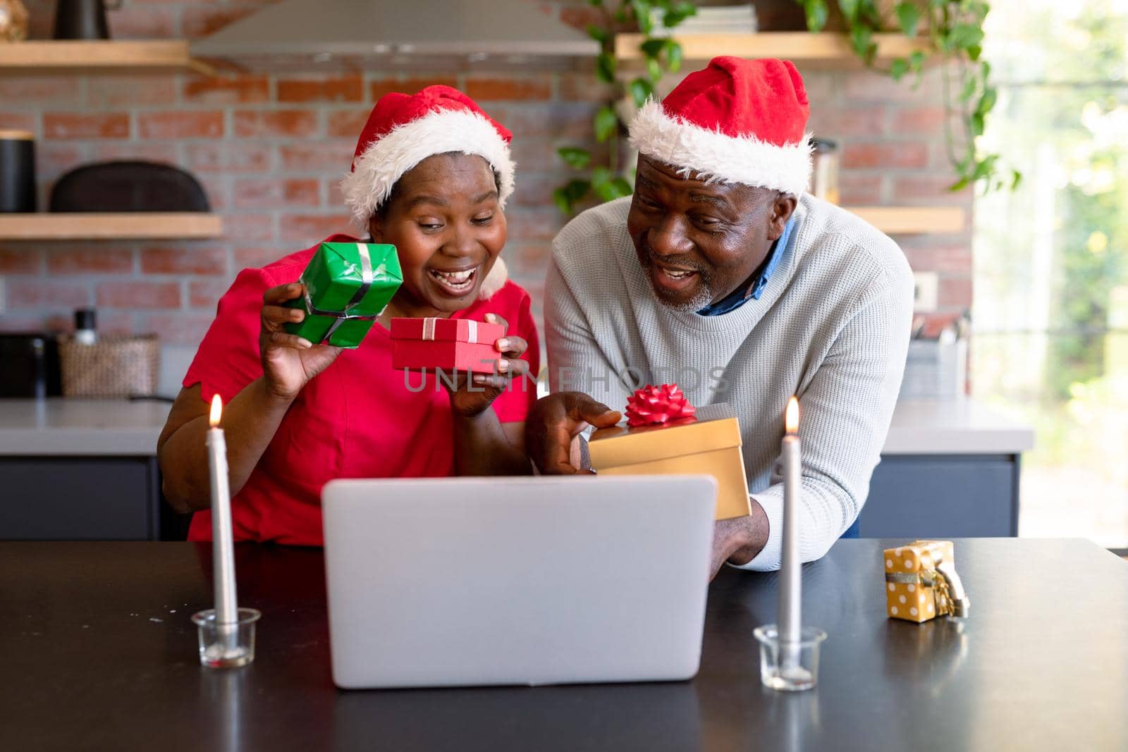 Happy african american senior couple having video call on laptop in kitchen at christmas time by Wavebreakmedia