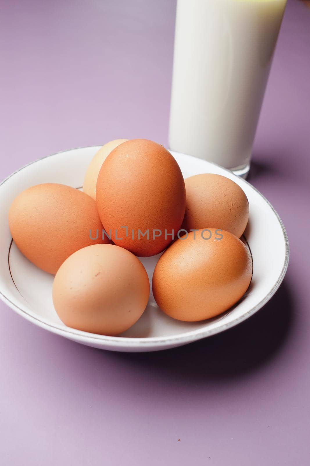 eggs in a bow and a glass of milk on table ,