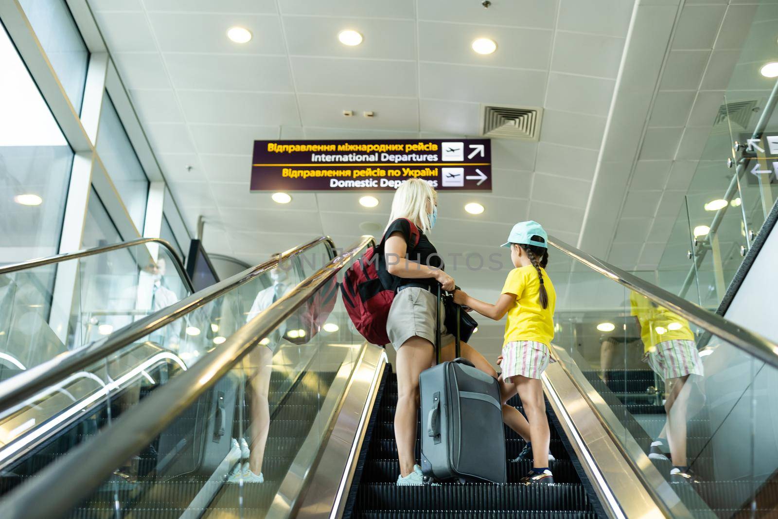 happy mother and daughter at airport travelling together.