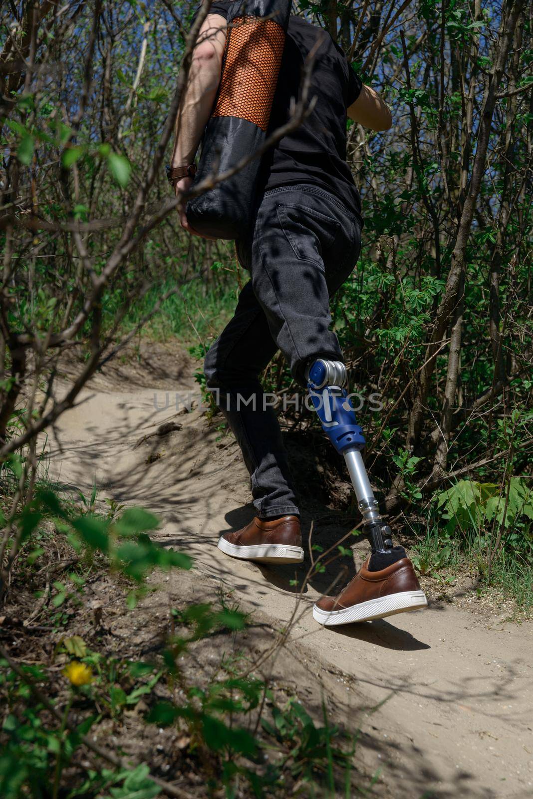 a man on a prosthetic leg travels the mountains. Dressed in black jeans and a T-shirt, he carrying mat by Ashtray25