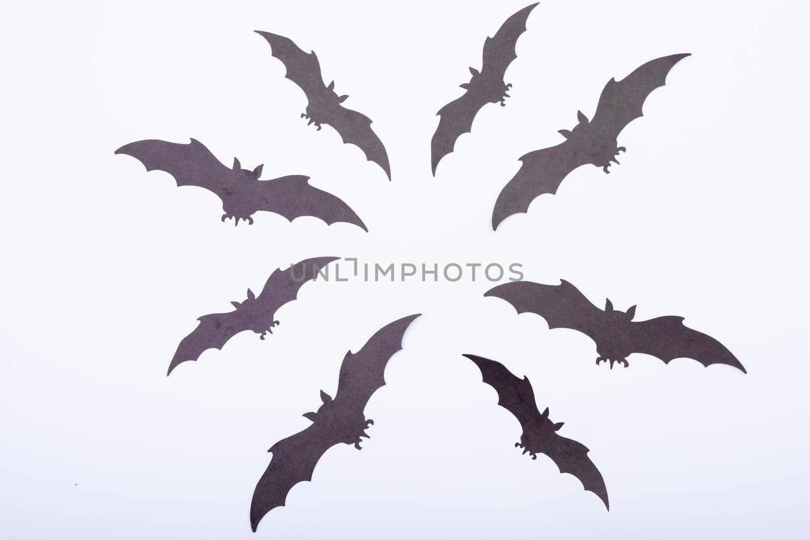 Composition of multiple halloween black bats flying on white background. halloween tradition and celebration concept.