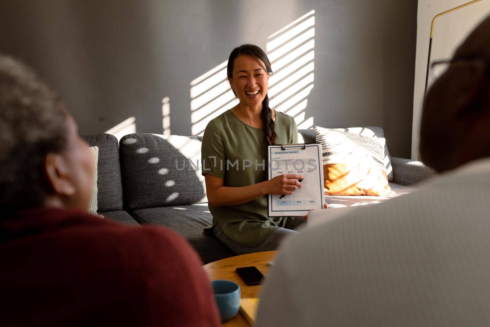 African american senior couple having meeting with happy asian female financial advisor at home. retirement lifestyle, elderly support and spending time at home.