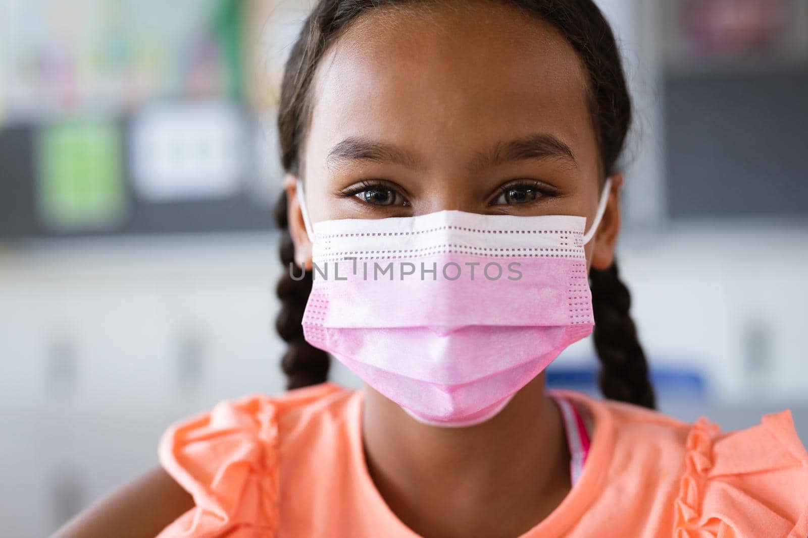 Portrait of african american girl wearing face mask at school by Wavebreakmedia
