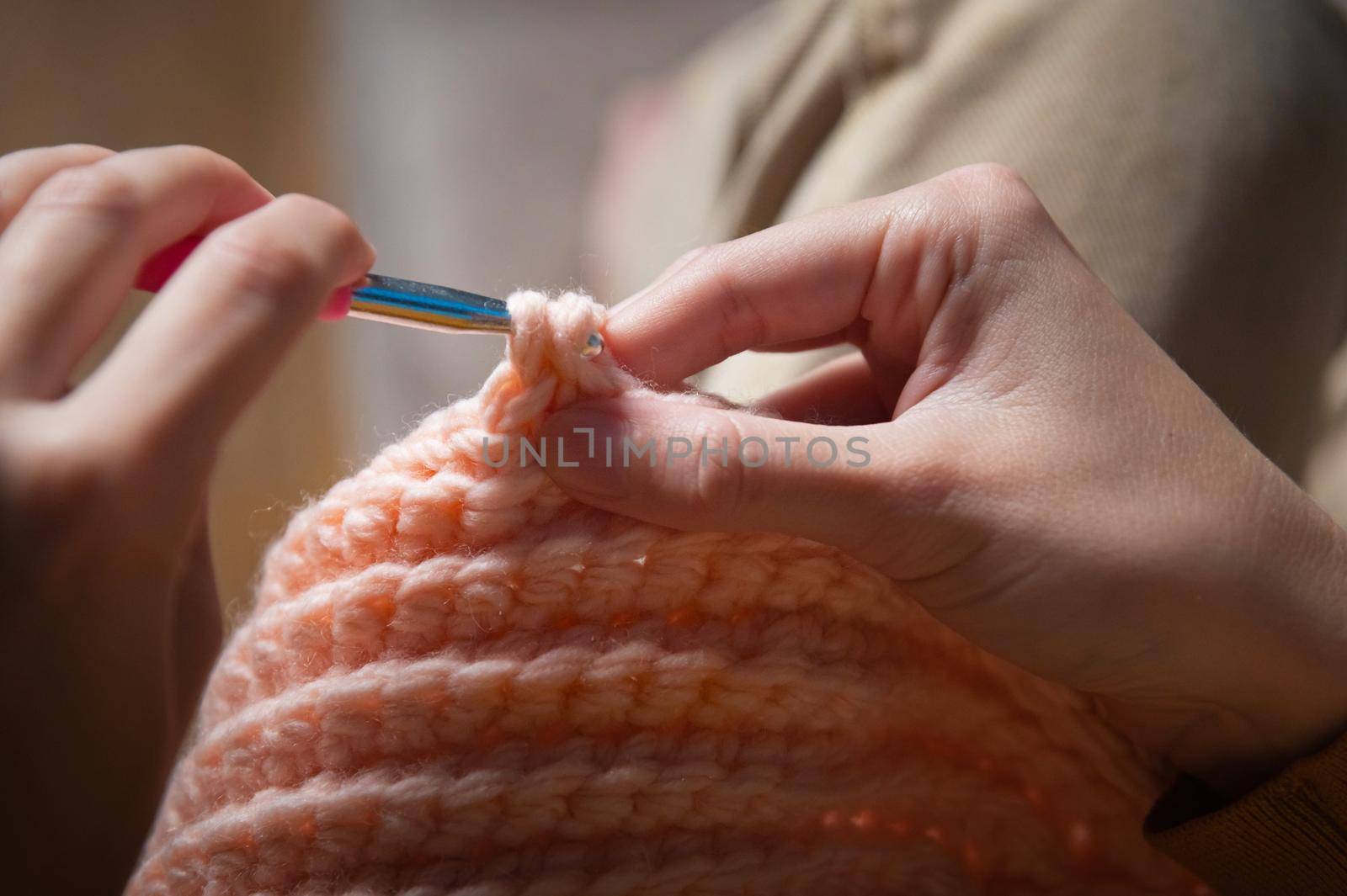 female hands close-up, crocheting clothes on the sofa at home, handmade by yanik88